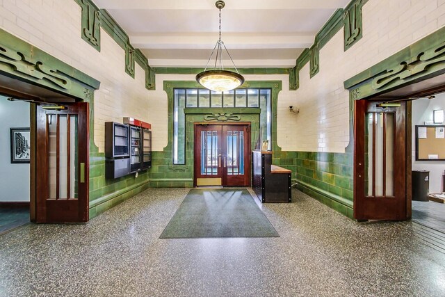 foyer entrance with beam ceiling and speckled floor