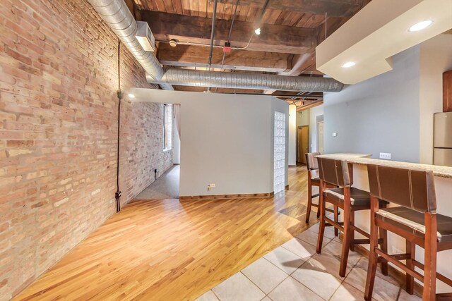 interior space featuring brick wall and light wood-type flooring