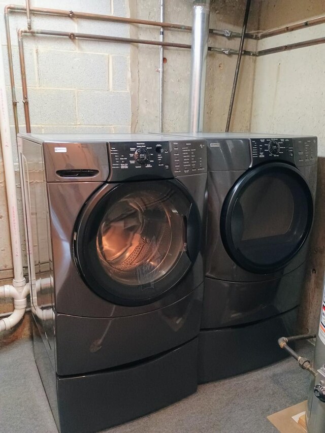 clothes washing area featuring laundry area, carpet, and washer and dryer