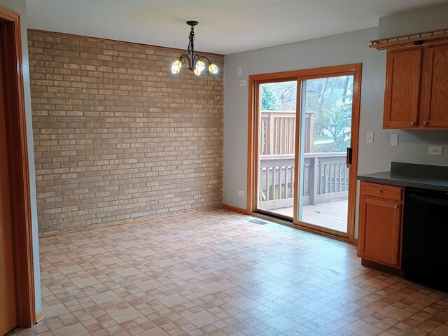 unfurnished dining area featuring brick wall, an inviting chandelier, and baseboards