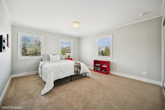carpeted bedroom featuring crown molding, baseboards, and visible vents