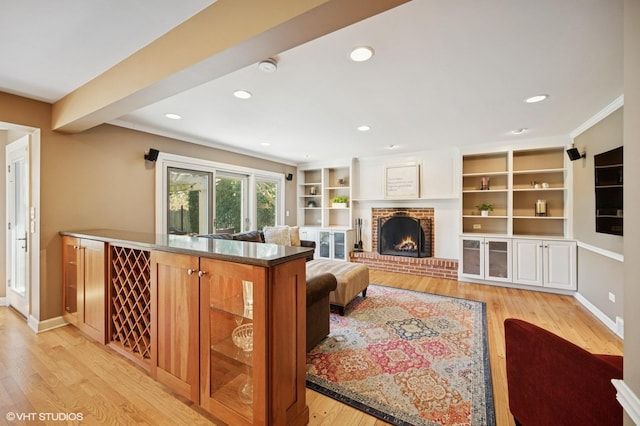 living area with light wood-style floors, recessed lighting, baseboards, and a brick fireplace