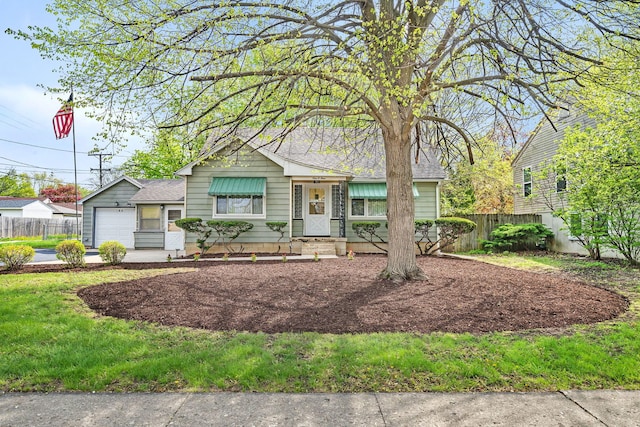 ranch-style house with a garage, roof with shingles, and fence