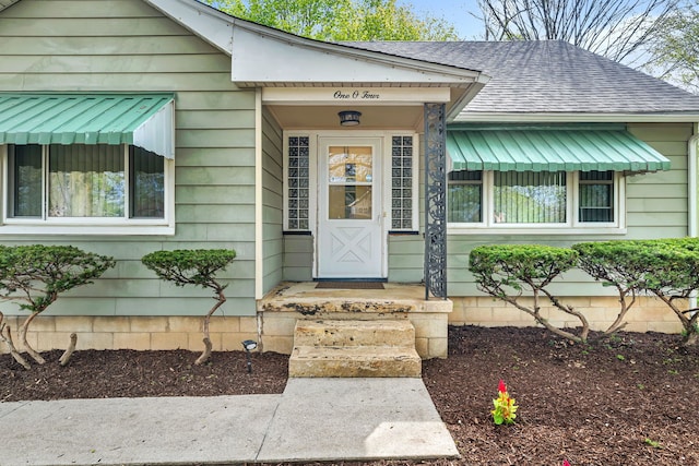 entrance to property featuring a shingled roof