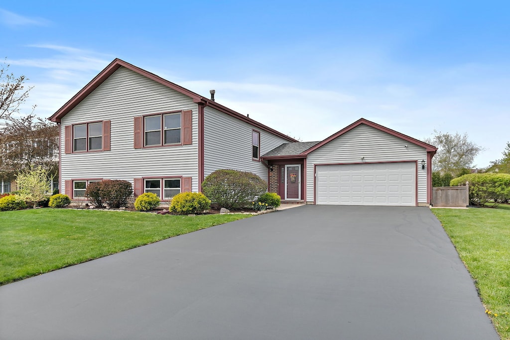 705 Old Mill Grove Rd, Lake Zurich, IL 60047 - tri-level home featuring an attached garage, a front lawn, and aphalt driveway