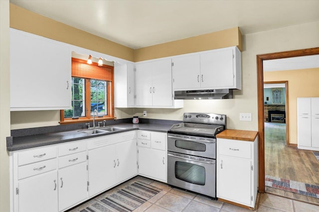 kitchen featuring a ceiling fan, dark countertops, appliances with stainless steel finishes, white cabinets, and under cabinet range hood