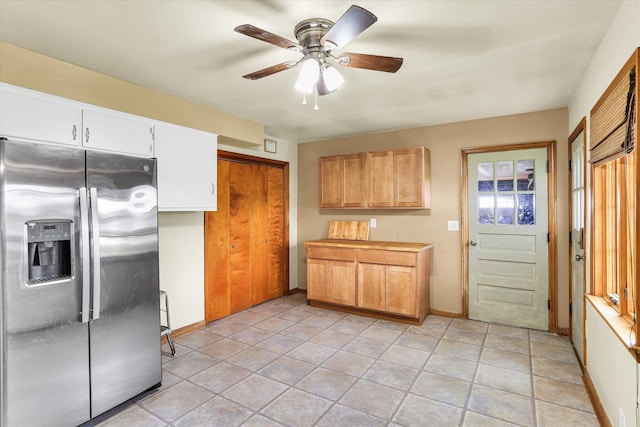 kitchen featuring baseboards, ceiling fan, and stainless steel refrigerator with ice dispenser