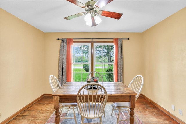 dining room with baseboards, a ceiling fan, and wood finished floors