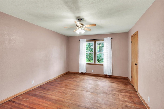 spare room with baseboards, a ceiling fan, and light wood-style flooring