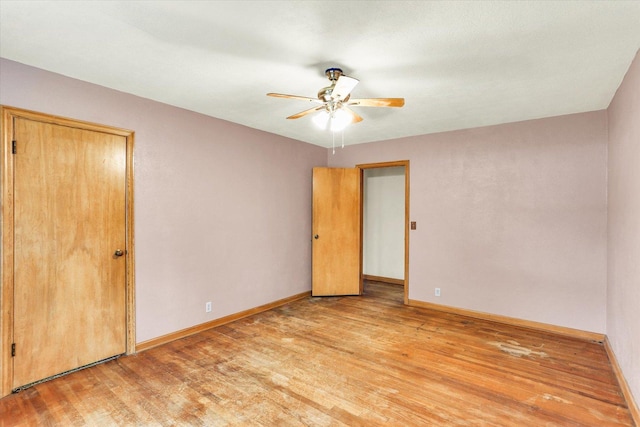 unfurnished room featuring light wood-type flooring, a ceiling fan, and baseboards