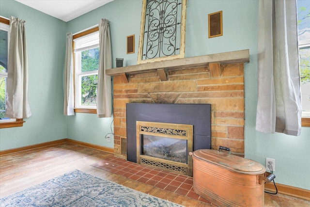 room details featuring baseboards, a fireplace with flush hearth, and wood finished floors