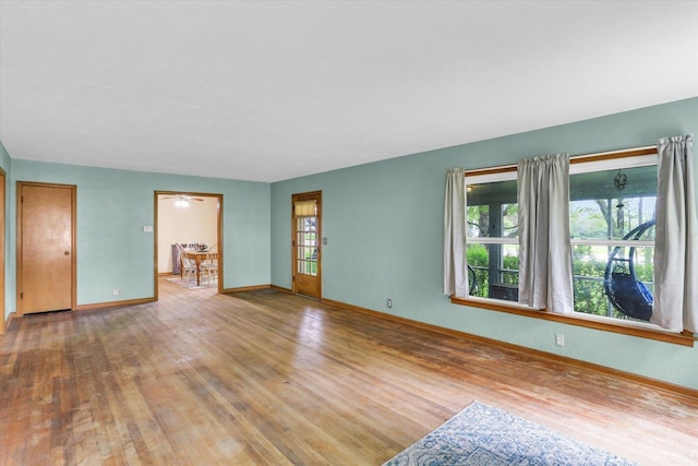 unfurnished living room with baseboards and wood finished floors