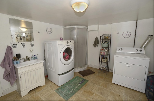 laundry area with washing machine and clothes dryer, laundry area, and a sink