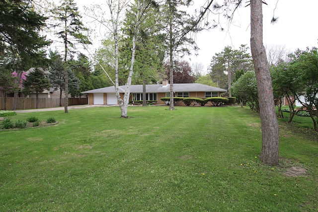 exterior space featuring fence, an attached garage, and driveway