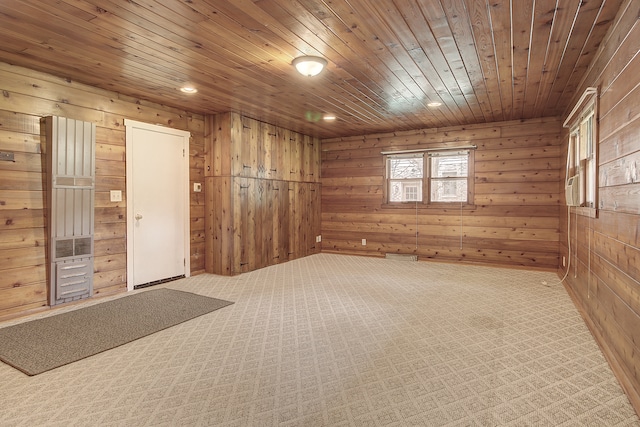carpeted spare room featuring wooden walls and wood ceiling