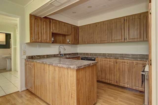 kitchen featuring open shelves, a peninsula, dark countertops, a sink, and light wood finished floors