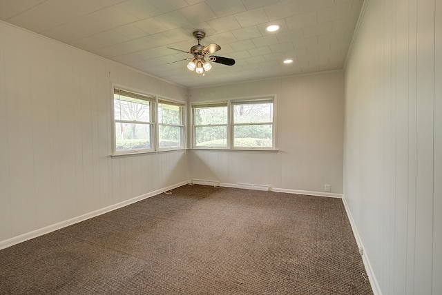 spare room featuring recessed lighting, wood walls, ceiling fan, and dark carpet