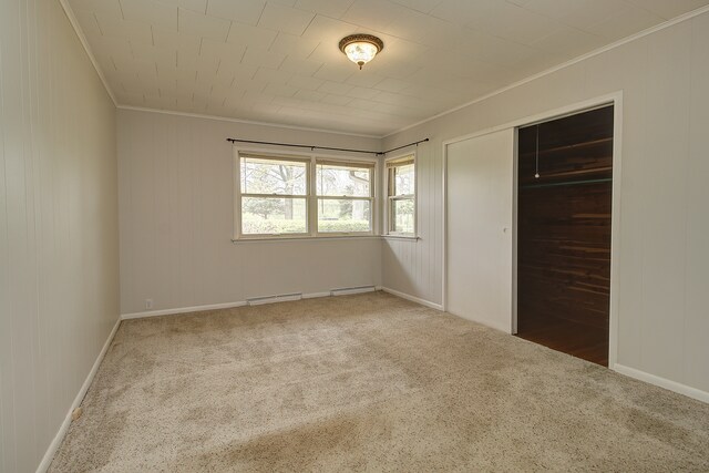 unfurnished bedroom with visible vents, ornamental molding, carpet, and a closet
