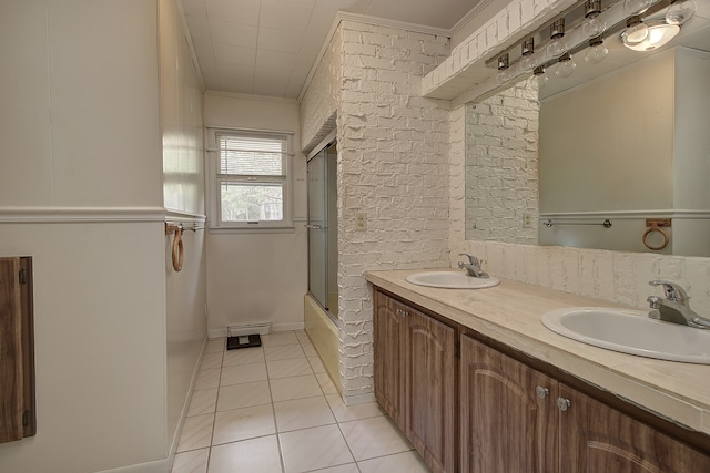 full bath featuring double vanity, tile patterned floors, ornamental molding, and a sink