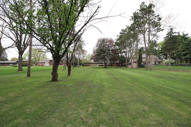 view of yard with a storage shed, fence, and an outbuilding