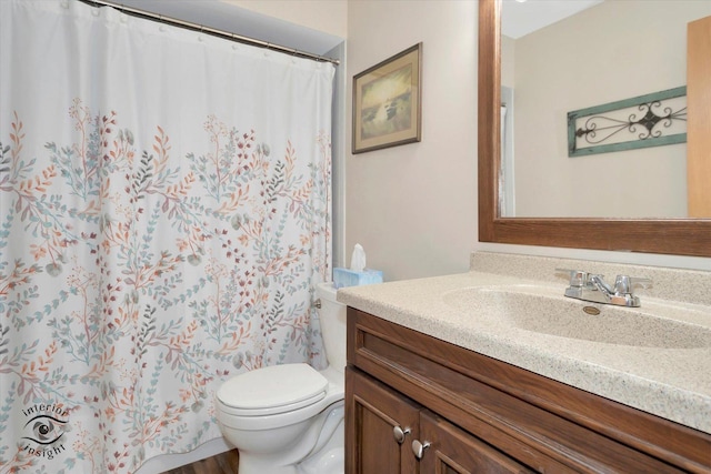 bathroom with toilet, vanity, and a shower with shower curtain