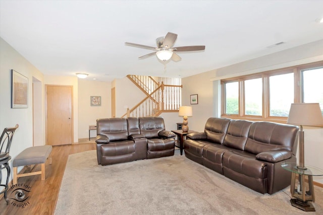 living room featuring stairway, ceiling fan, and light wood-style flooring