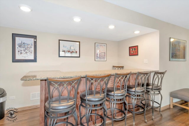 indoor dry bar featuring baseboards, wood finished floors, and recessed lighting