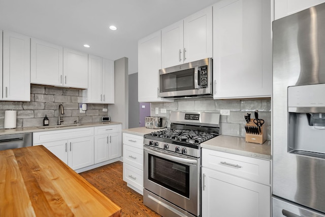 629 Sheffield Ln, Bolingbrook, IL 60440 - kitchen featuring butcher block counters, white cabinetry, a sink, backsplash, and stainless steel appliances
