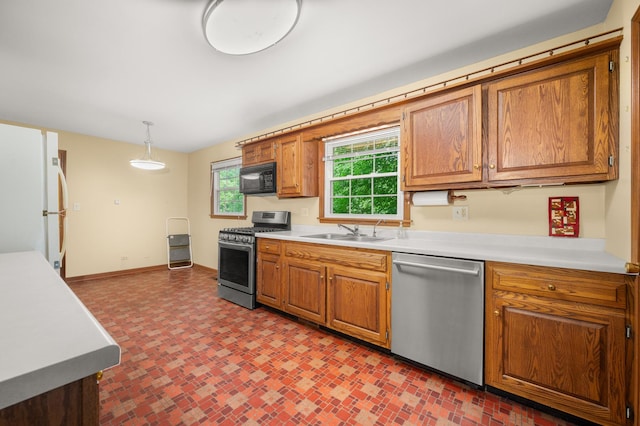 726 Parkside Dr, Sycamore, IL 60178 - kitchen featuring stainless steel appliances, a sink, light countertops, baseboards, and brown cabinetry