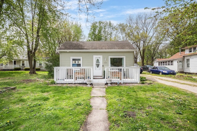 bungalow-style house featuring a front lawn and a deck