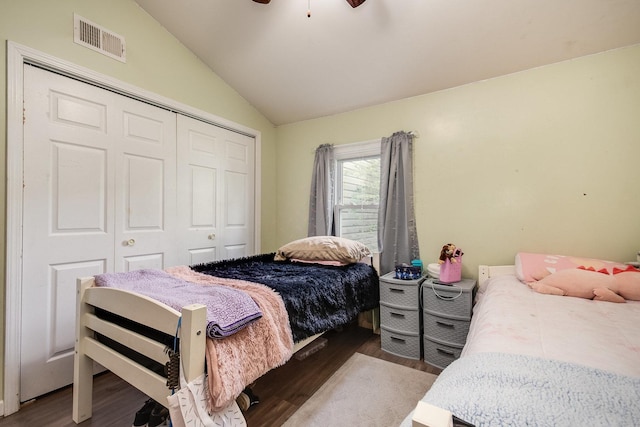 bedroom with a ceiling fan, visible vents, vaulted ceiling, wood finished floors, and a closet