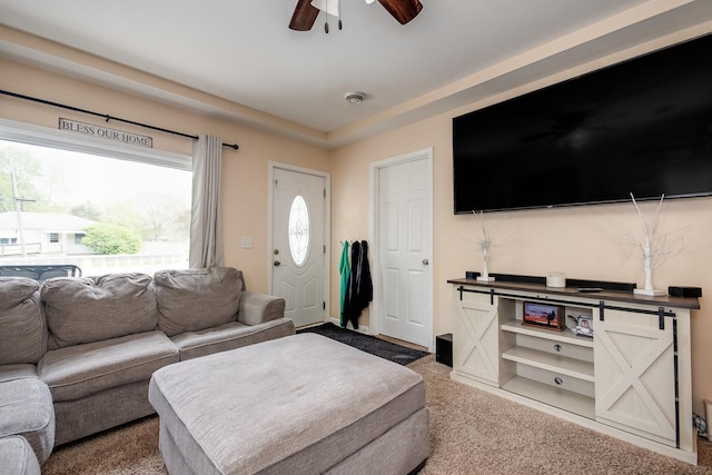 carpeted living room with a ceiling fan and a healthy amount of sunlight