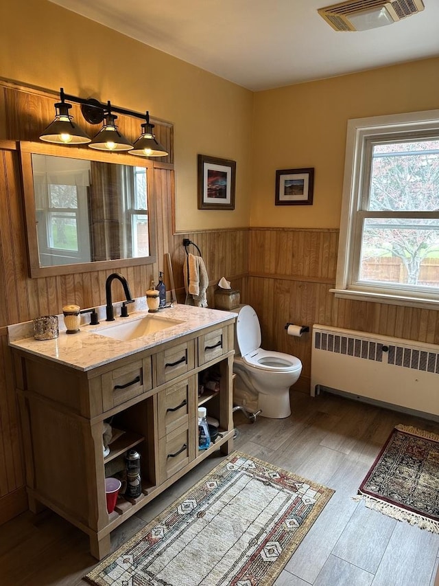 436 E Seminary Ave, Onarga, IL 60955 - bathroom with radiator, a wainscoted wall, plenty of natural light, vanity, and wood finished floors