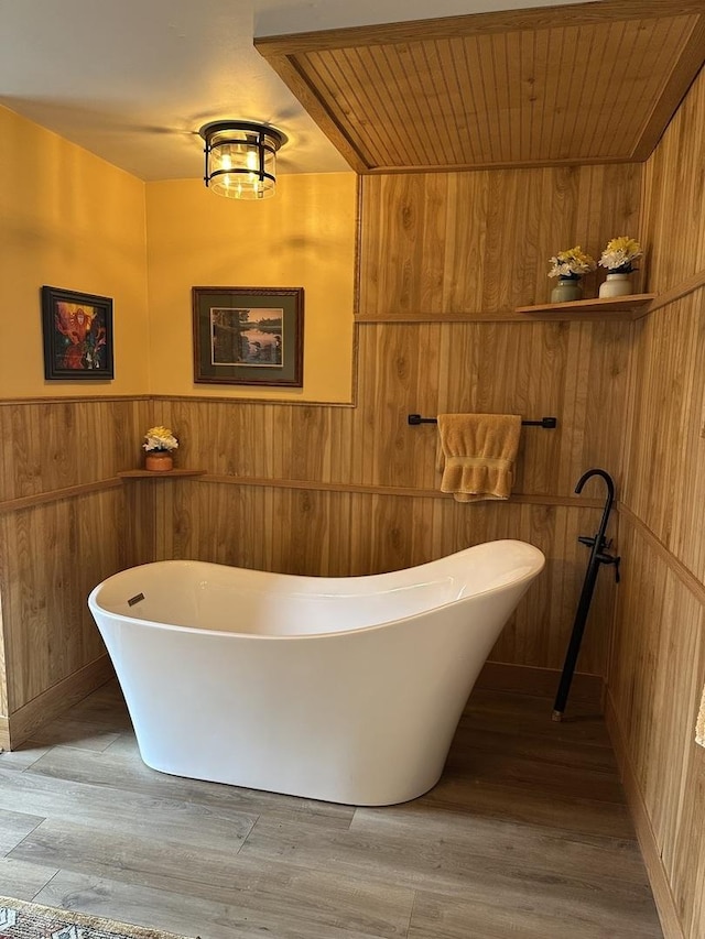 436 E Seminary Ave, Onarga, IL 60955 - bathroom with wood walls, a freestanding tub, and wood finished floors