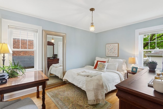 bedroom featuring light wood-style flooring and ornamental molding