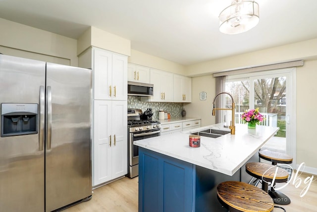 395 Magnolia Ave, Gurnee, IL 60031 - kitchen with decorative backsplash, appliances with stainless steel finishes, a sink, light wood-style floors, and white cabinetry