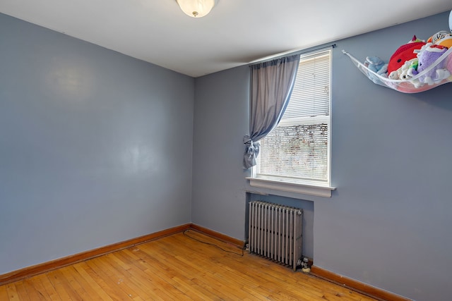 2335 N Merrimac Ave, Chicago, IL 60639 - unfurnished room featuring radiator heating unit, baseboards, and wood-type flooring