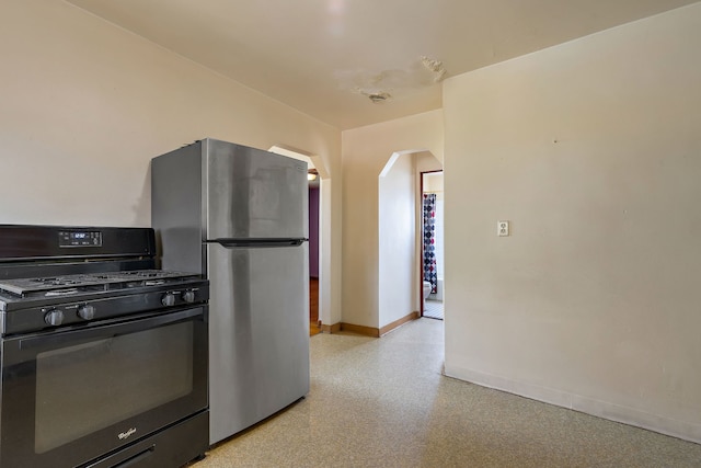 2335 N Merrimac Ave, Chicago, IL 60639 - kitchen with gas stove, freestanding refrigerator, arched walkways, and baseboards
