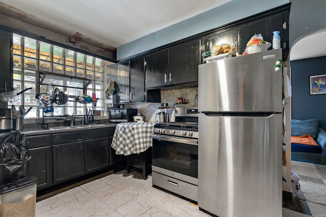 2335 N Merrimac Ave, Chicago, IL 60639 - kitchen featuring stainless steel appliances, a sink, dark cabinetry, decorative backsplash, and dark countertops