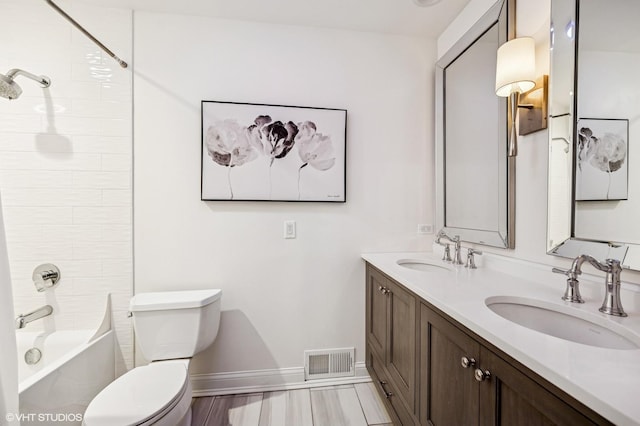 full bath with toilet, baseboards, visible vents, a sink, and double vanity