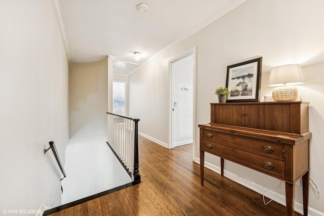 hall featuring wood finished floors, ornamental molding, attic access, an upstairs landing, and baseboards