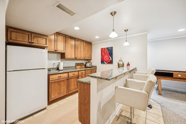 kitchen featuring a sink, freestanding refrigerator, visible vents, and recessed lighting