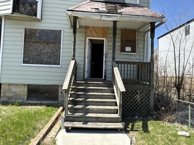 entrance to property featuring fence and a porch