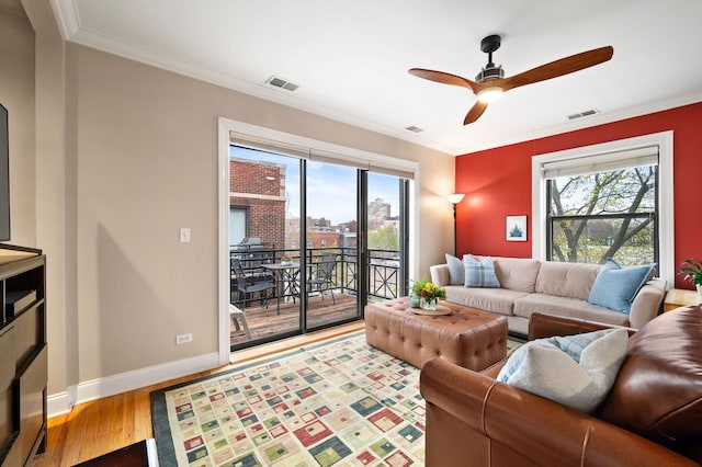 living room featuring visible vents, baseboards, ceiling fan, and wood finished floors