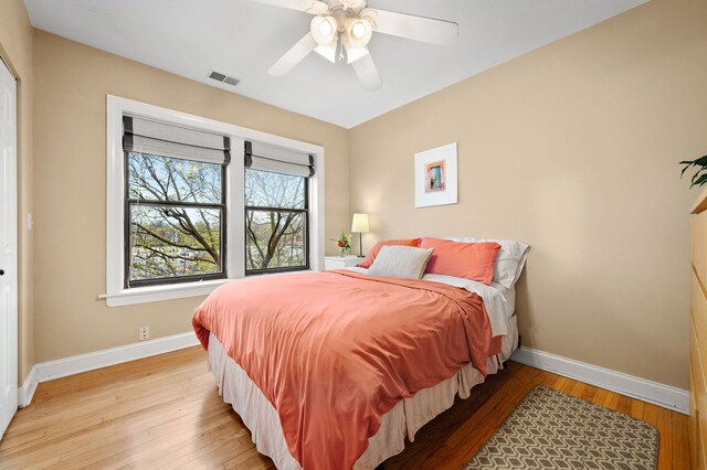 bedroom with ceiling fan, baseboards, visible vents, and light wood-style flooring