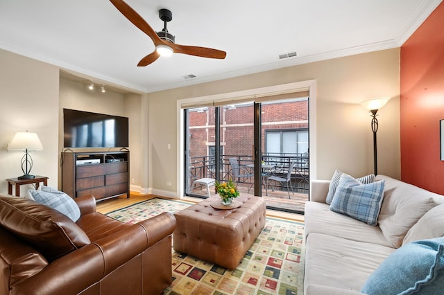 living room with crown molding, a ceiling fan, and visible vents
