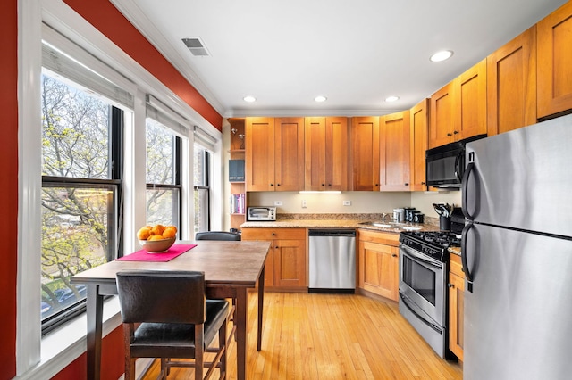 kitchen with appliances with stainless steel finishes, open shelves, ornamental molding, recessed lighting, and light wood-style flooring