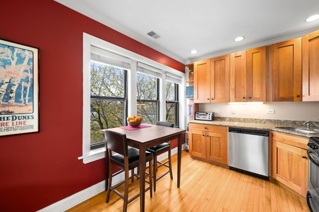kitchen featuring a sink, light wood finished floors, dishwasher, visible vents, and ornamental molding