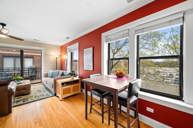 bedroom featuring light wood-style floors, crown molding, and multiple windows