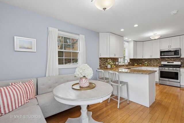 69 N Idlewild Ave, Mundelein, IL 60060 - kitchen with stainless steel appliances, a peninsula, tasteful backsplash, white cabinetry, and recessed lighting